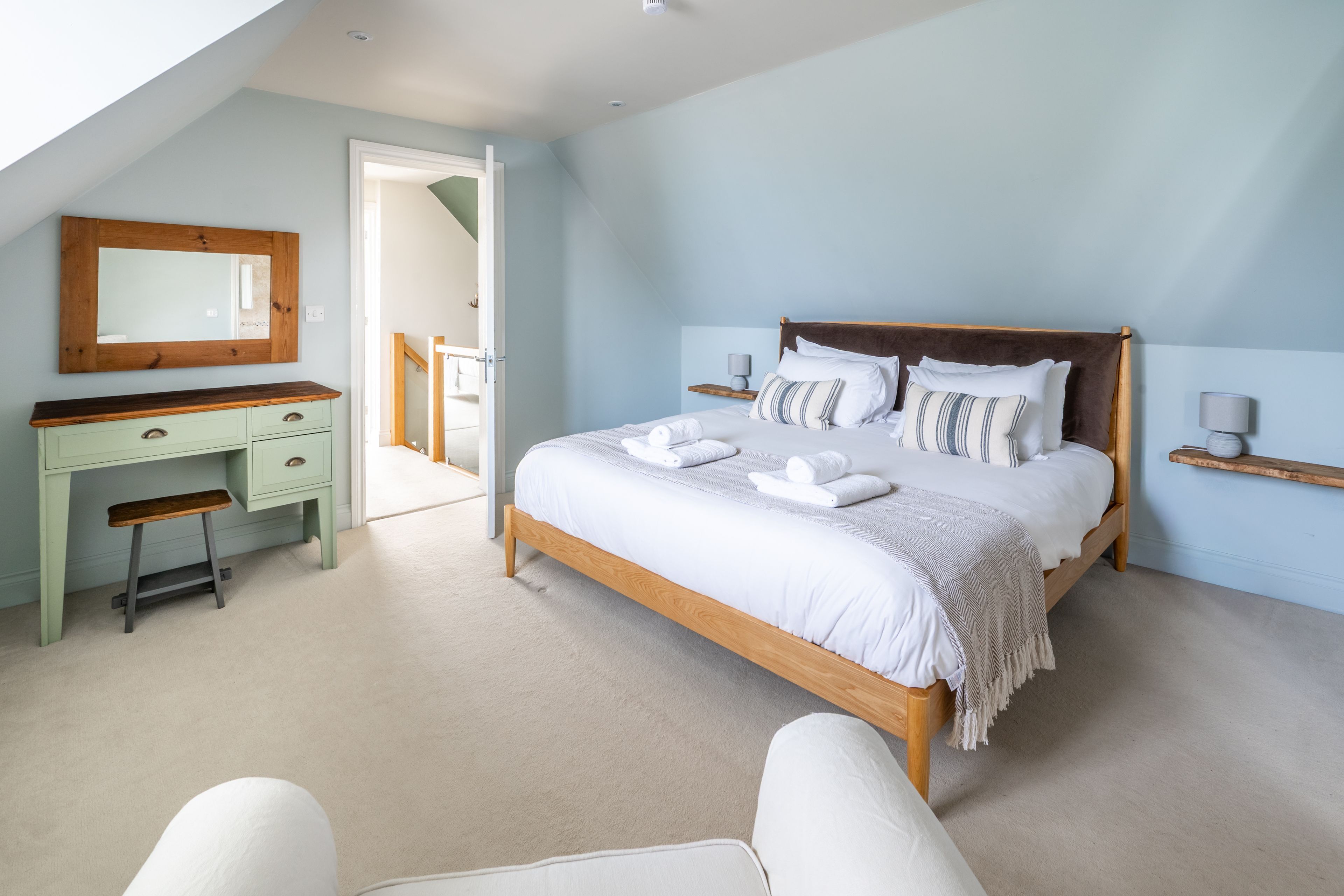 A bedroom with a bed, a desk, and a chair.