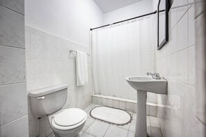 Ein Badezimmer mit Toilette, Waschbecken und Duschvorhang.