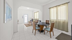 A dining area with a round table, chairs, and a view of a hallway. - Cozy Family Apartment at San Juan (San Juan)