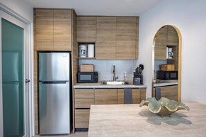 Eine moderne Küche mit Holzausstattung, Edelstahlgeräten und einer einzigartigen, grünen Glasdoor.