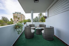 A balcony with wicker furniture, green artificial turf, and potted plants. - Budget Friendly Apt with 2 Balconies Near Beach (San Juan)