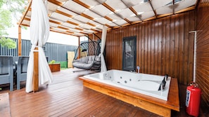 A wooden deck with a hot tub, a hanging chair, and a covered seating area. - Elite Escape Village Hotel (Catalca)