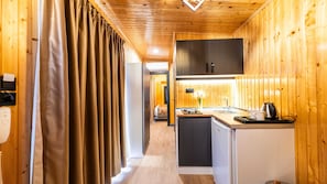 A compact kitchen with wooden walls, a built-in oven, and a sink.