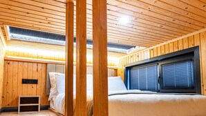 A wooden cabin interior with a bunk bed, a small kitchenette, and a window with blinds. - Elite Escape Village Hotel (Catalca)