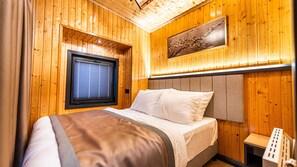 A wooden-paneled room with a bed, a window with blinds, and a wall-mounted artwork. - Elite Escape Village Hotel (Catalca)