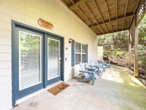 A covered porch with a row of blue chairs and a wooden sign above the doors. - The Gathering Haus - 10% OFF or 4th Night Free - Ask for details! (Helen)