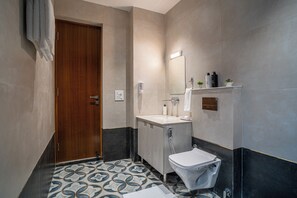 Un bagno con una porta di legno, un lavandino, un water e uno specchio.
