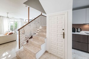 Eine Treppe mit einem hölzernen Geländer und einer weißen Tür.