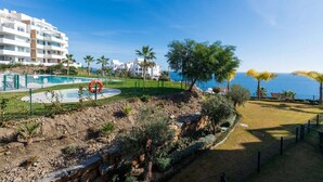 A coastal hotel with a swimming pool, palm trees, and a view of the sea. - Luxury Pool View Isea 1111 (Torrox)