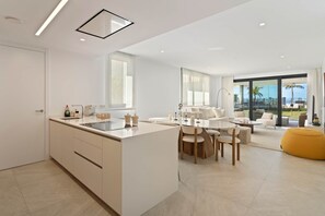 Eine moderne Küche mit Kochinsel, Essbereich mit Stühlen und einer Couch.