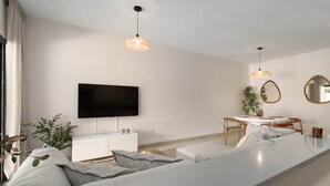 A modern living room with a large TV, a dining area, and a sofa. - RDR541 - Gorgeous 2 bed Apt. in Los Flamingos (Marbella)