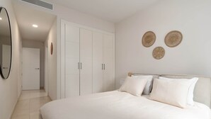 A bedroom with a bed, a wardrobe, and a mirror. - RDR541 - Gorgeous 2 bed Apt. in Los Flamingos (Marbella)