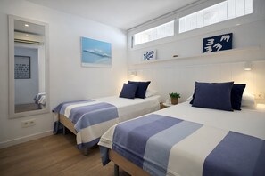 Ein Hotelzimmer mit zwei Betten, einem großen Spiegel, einem Fenster und einem Wandregal mit Dekoration.