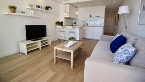 En moderne stue med tv, sofa og spiseplads.