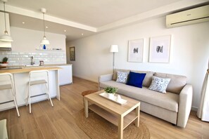 Ein modernes Wohnzimmer mit Küche, einer Couch, einem Couchtisch und einer Bar.