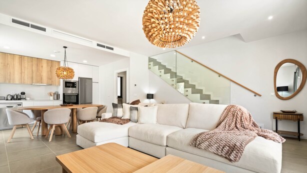 Un espacio habitable moderno con cocina, comedor y escalera.
