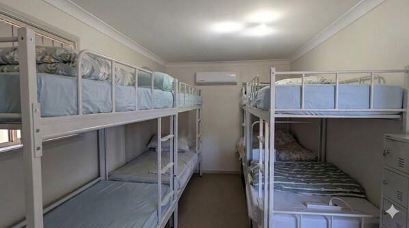 A bunk bed room with a white ceiling, a white wall, and a white door.
