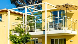 A yellow building with a balcony, glass railings, and a tree in the background. - Sea View Duplex for 8 on Var Coast (Six-Fours-les-Plages)