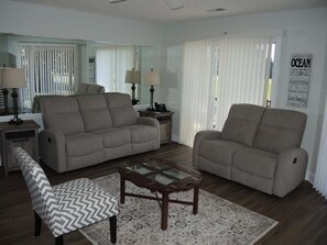 A living room with two sofas, a coffee table, and a patterned rug. - 104m 1 Bedroom Condo (Calabash)