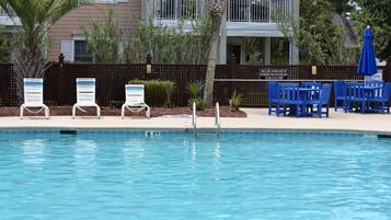 A swimming pool with a deck area, lounge chairs, and a sign indicating a 6 ft depth.