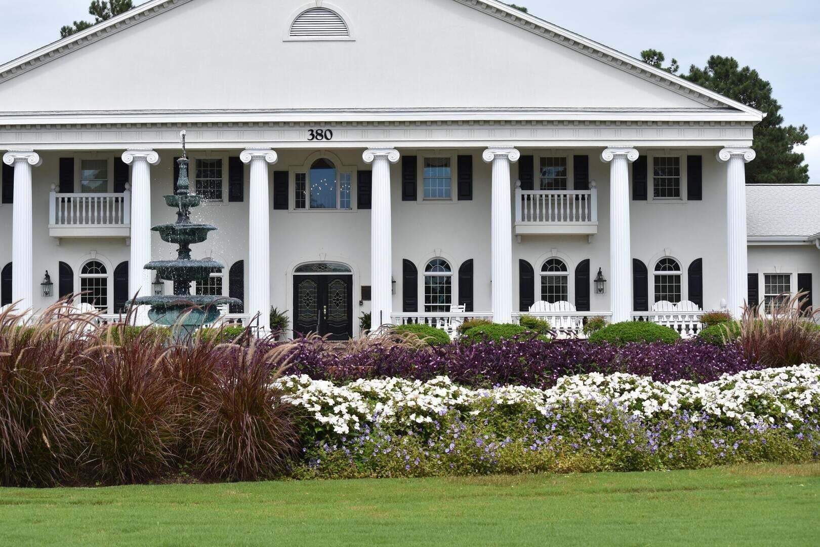 A large white building with a symmetrical facade, columns, and a central entrance.