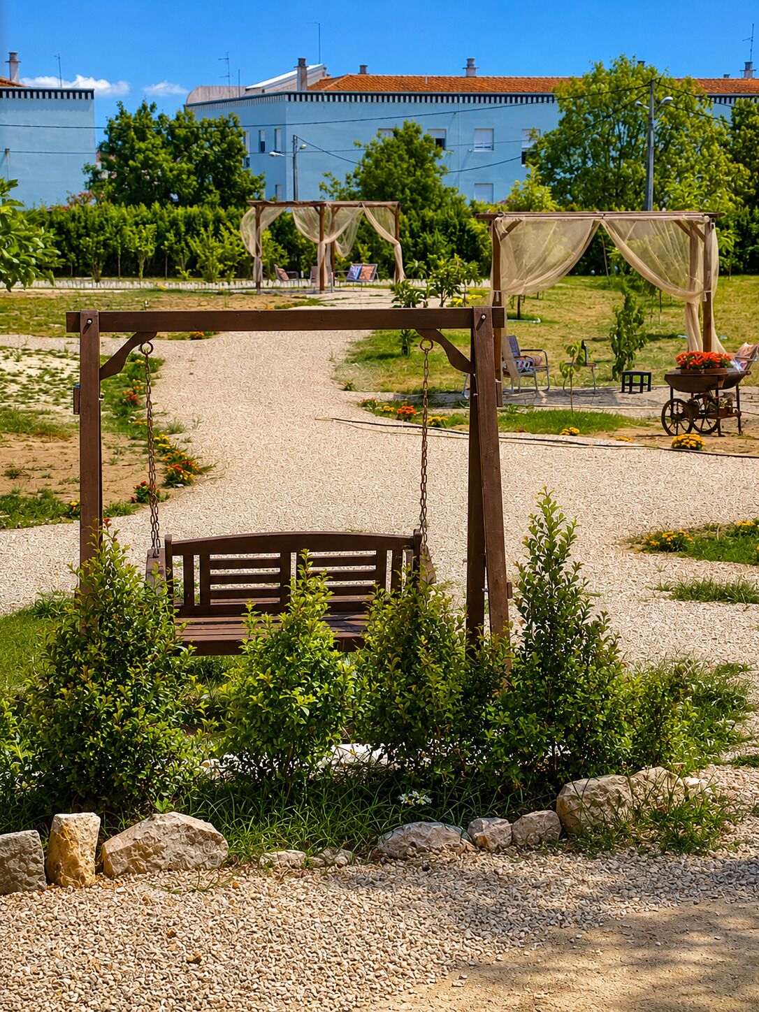 Un parc avec une balançoire, un banc et une petite table décorée de fleurs.