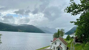 A lakeside house with a dock, a small boat, and a path leading to the house. - Cabin by Telemark Canal with private beach (Høydalsmo)