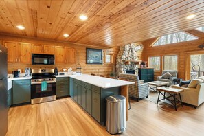 L’intérieur d’une cabane en rondins comprend une cuisine, un coin repas et un salon.