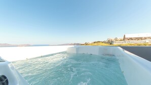 Un jacuzzi con vistas al mar y un edificio al fondo.