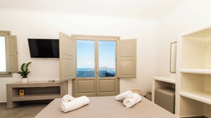 Una habitación de hotel con cama, televisión, armario y vista al mar.