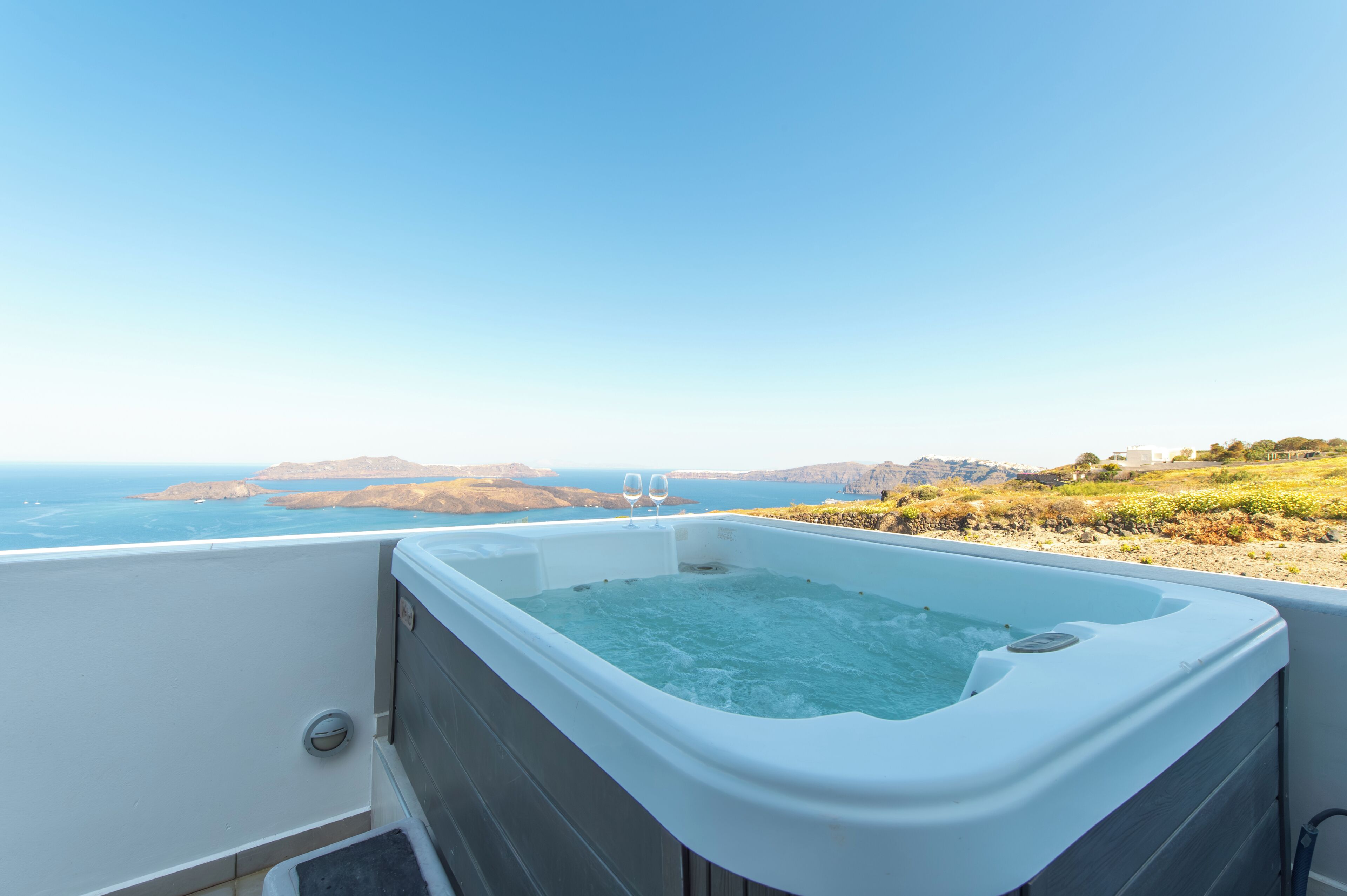 Un jacuzzi con vistas despejadas al océano y colinas al fondo.