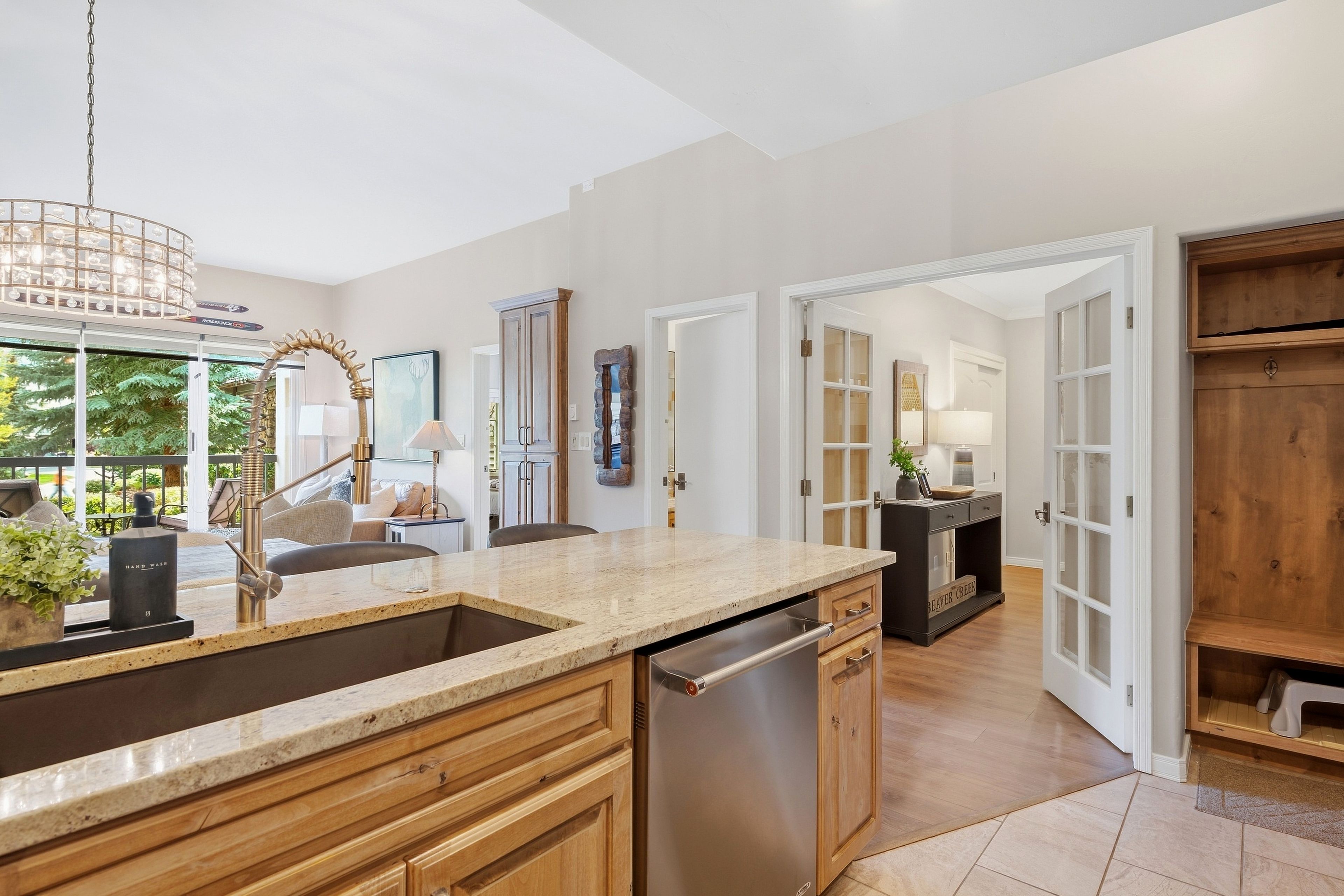 A modern kitchen with a granite countertop, stainless steel appliances, and wooden cabinetry.