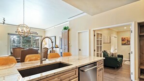 A kitchen with a granite countertop, stainless steel dishwasher, wooden cabinets, and a pendant light. - Beaver Creek Ski-In/Ski-Out Retreat  LB108 (Beaver Creek)