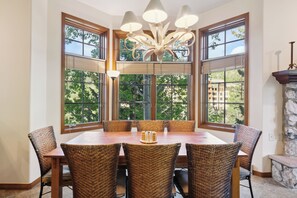 A dining area with a large table, wicker chairs, and a chandelier. - Slopeside Luxury, Pool, Hot Tubs, Conceirge | LB114 (Beaver Creek)