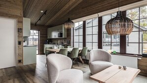 Un intérieur moderne comprenant un coin repas, une cuisine et de grandes fenêtres.