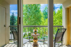 Ein Balkon mit Tisch, zwei Stühlen und einer Champagnerflasche.