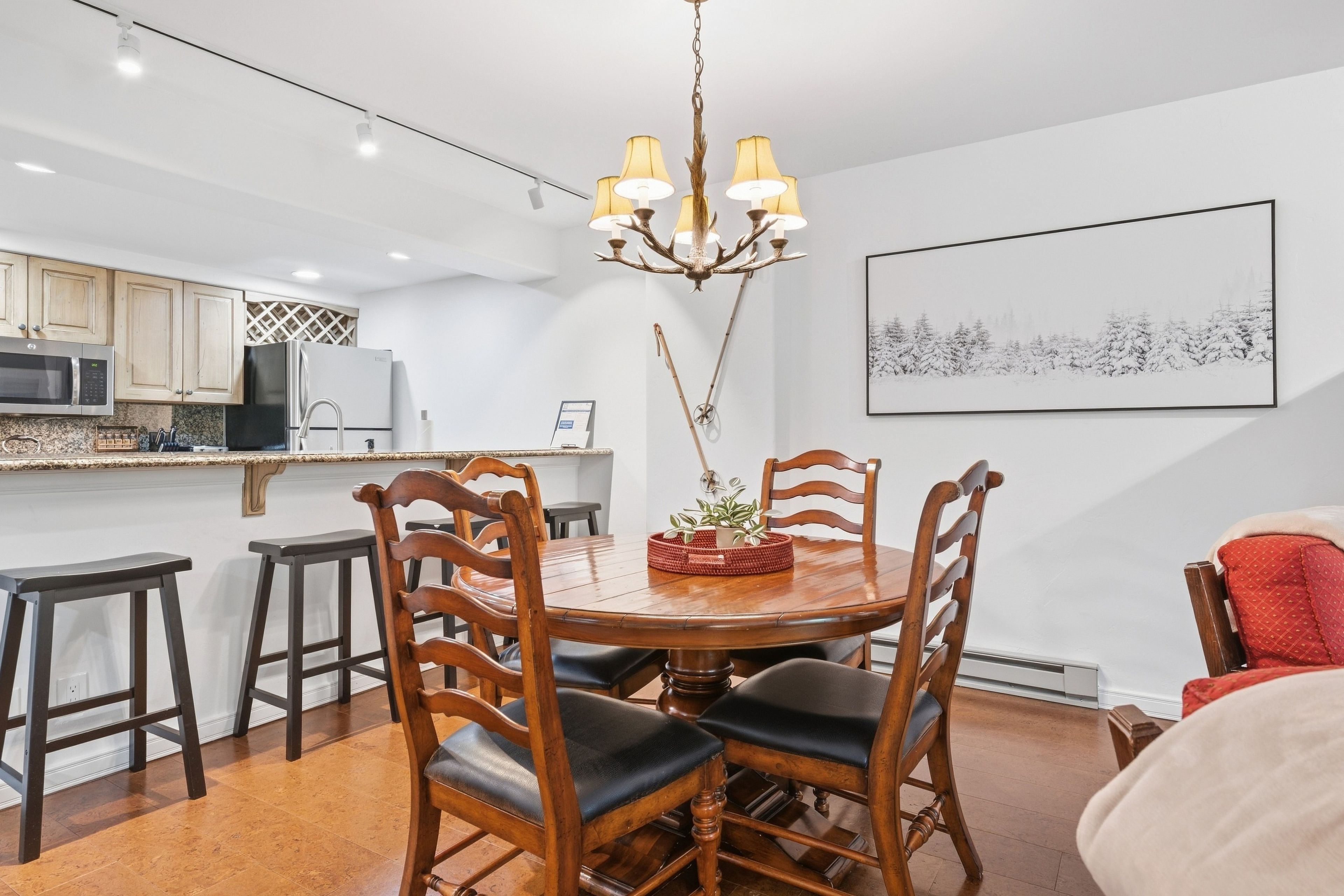 A dining area with a wooden table, chairs, and a chandelier.