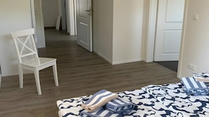 Un dormitorio con una cama, una silla y una puerta.