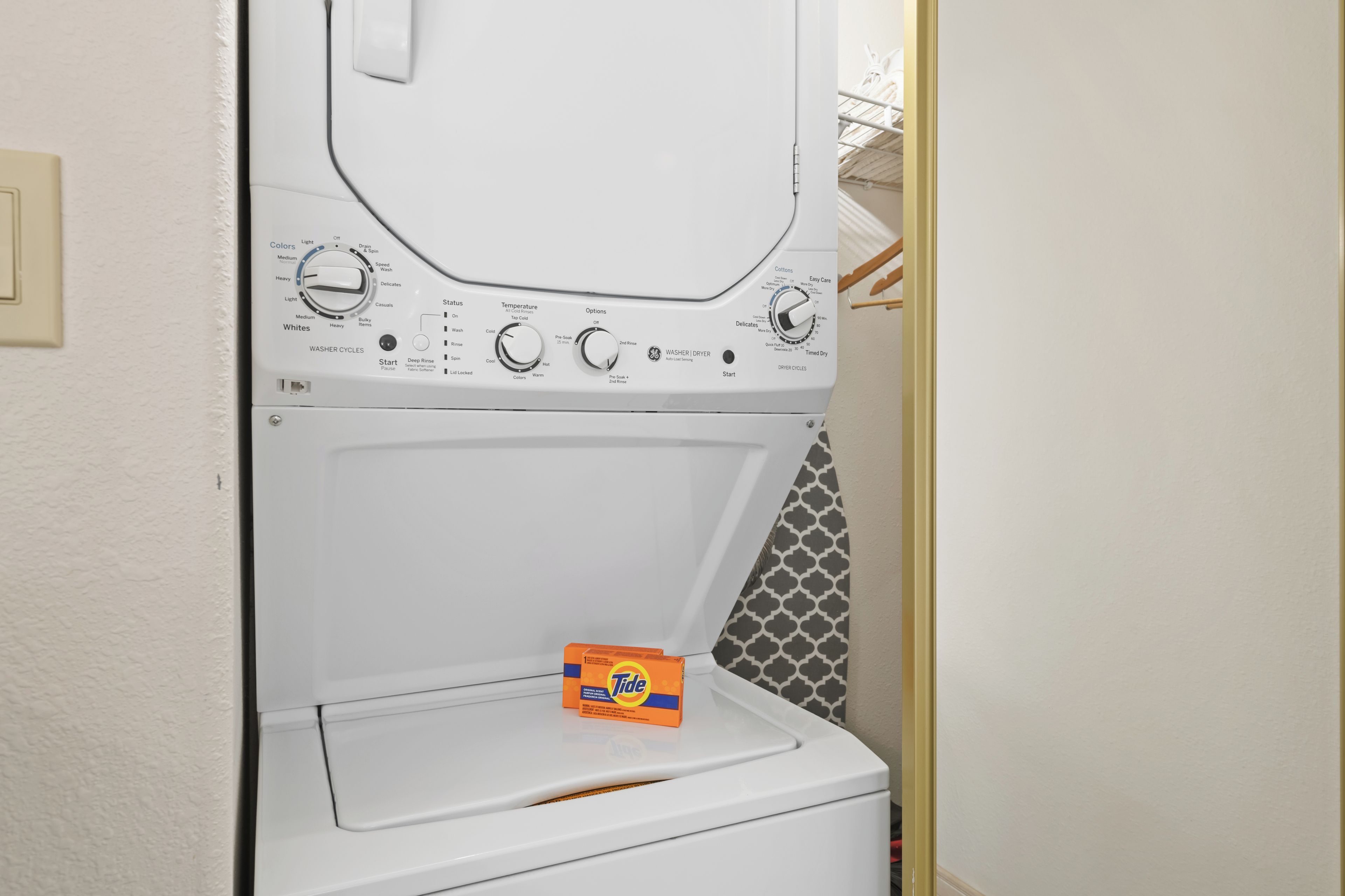 A front-loading washing machine with Tide detergent.