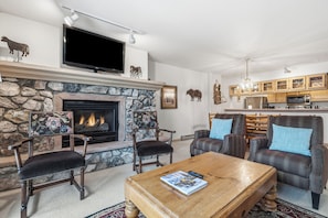 Ein Wohnzimmer mit Kamin, Fernseher und Sitzecke.