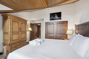 A hotel room with a large bed, wooden wardrobe, and a painting on the wall. - Ski-In/Ski-Out, Resort Amenities, Shuttle | LB309 3 Bedroom (Beaver Creek)