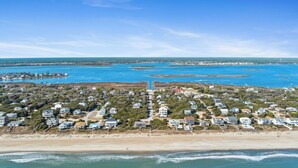 Vista aérea de una zona residencial costera con casas, una playa y un puerto deportivo.