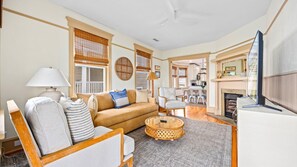 A living room with a sofa, armchairs, a coffee table, and a fireplace.