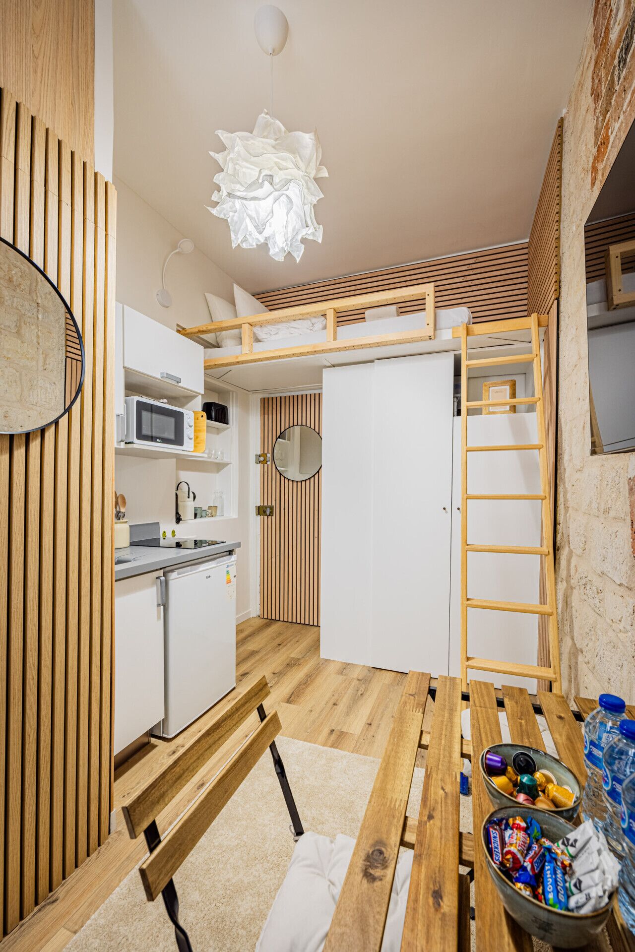 Une cuisine compacte équipée d’un four à micro-ondes, d’un évier et d’un comptoir en bois.