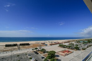 A coastal view with a beach, parking area, and buildings. - FLH Monte Gordo Balcony Flat (Monte Gordo)