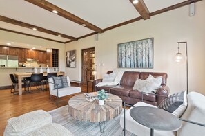 Ein geräumiger Wohnbereich mit einem runden Couchtisch, einer braunen Ledersofa und einem Essbereich mit Holzschränken und einer modernen Küche.