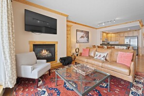 A living room with a fireplace, a sofa, a coffee table, and a television. - Beaver Creek Slope-Side Luxury | UB301 (Beaver Creek)