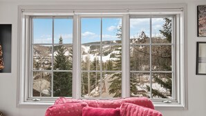 Una habitación con un ventanal que ofrece vistas a un paisaje nevado y una montaña.