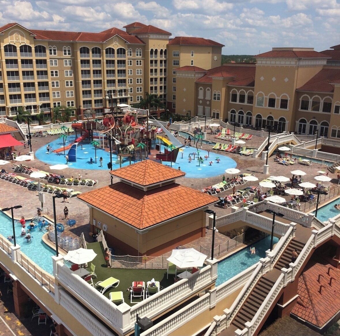 A hotel with multiple swimming pools, a water park, and a large building with balconies.