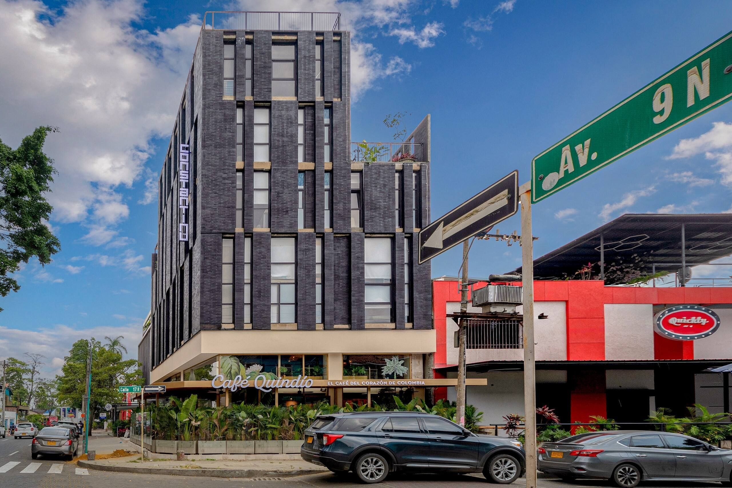 Un edificio moderno con una cafetería llamada 'Cafe Quindio' a nivel de calle.